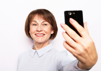 Fototapeta premium Portrait of her she nice attractive lovely pretty fashionable cheerful senior woman taking making selfie spending free time