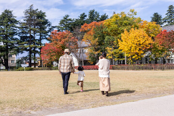 秋の公園を散歩する家族・ファミリー
