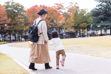 秋の公園で遊ぶママと子供
