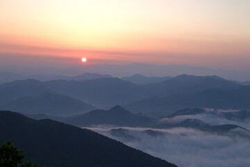 Orange sky background and sea of cloudscape above mountain at sunset, copy space