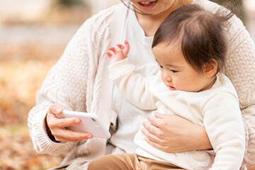 公園でスマホで遊ぶ親子
