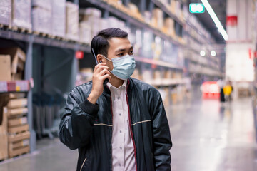 Soft focus Asian engineer or technician wearing mask,safety hard hat,uses radio communication check merchandise stock,security cargo management,warehouse,industry business logistic and export concept