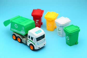 Garbage removal truck and garbage sorting bins on blue background