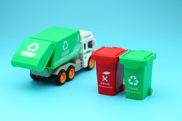 Garbage removal truck and garbage sorting bins on blue background