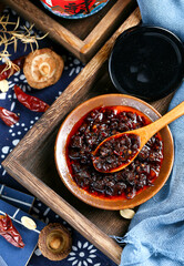 A wooden spoon to scoop up a spoonful of Sichuan chili sauce