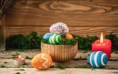 Bright colorful Easter eggs on a background made of old wooden boards covered with green moss