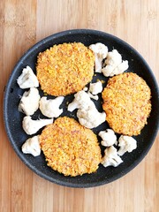 fried chicken and turkey cutlets with cauliflower in a frying pan