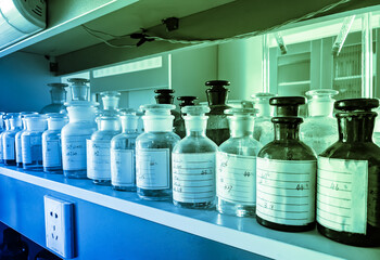 Glass vials of chemical reagents on a shelf