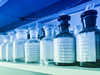 Glass vials of chemical reagents on a shelf