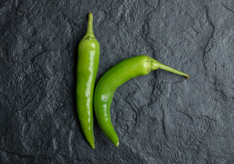 Top view of fresh hot peppers on black background