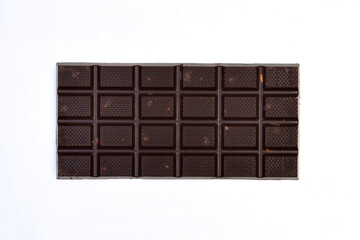 sweet and delicious whole chocolate bar is lying on white background, photo taken from above