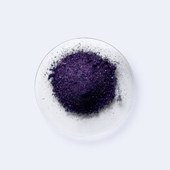 Potassium permanganate on chemical watch glass. KMnO4, a common chemical compound that combines manganese oxide ore with potassium hydroxide.