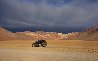 Four-wheel car with the beautiful palette of colors in the Salvador Dali Valley, Salar de Uyuni, Bolivia
