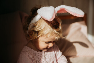 Baby girl wears rabbit ears.