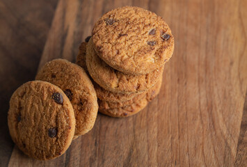 Stack of delicious chocolate chip cookies on wooden board