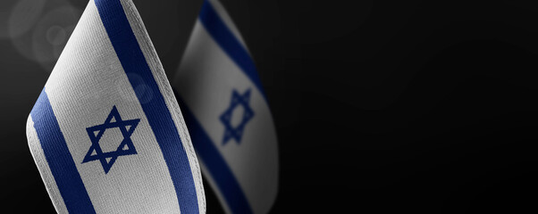 Small national flags of the Israel on a dark background