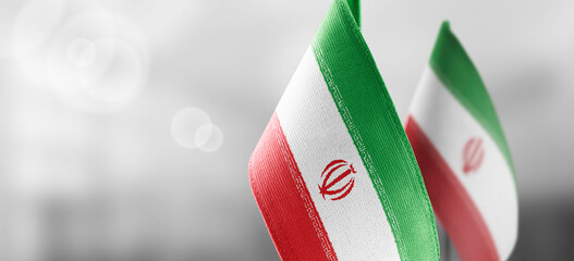 Small national flags of the Iran on a light blurry background