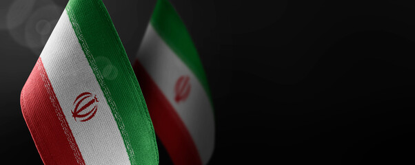 Small national flags of the Iran on a dark background - obrazy, fototapety, plakaty