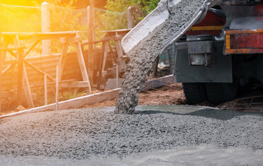 pouring a concrete mix at road construction site - obrazy, fototapety, plakaty