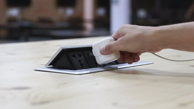 Pop-up power plug, man's hand held the plug into the outlet ,Unplugging after use, Opening of electrical circuits or plugging in electrical outlet.