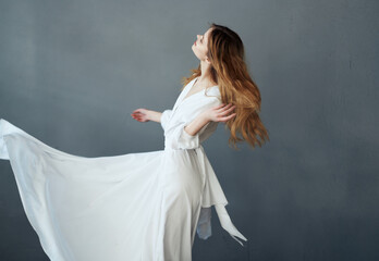 Fototapeta na wymiar Woman in white dress attractive sight glamor performance gray background