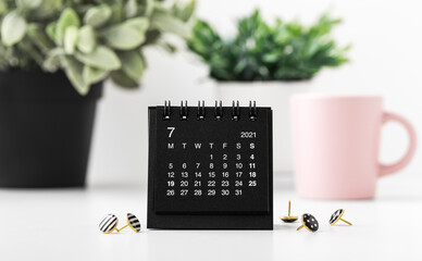 Black calendar with pins and plants
