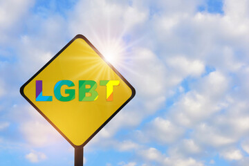 LGBT word on yellow sign on beautiful blue sky with fluffy cloud background. Lesbian gay bisexual transgender concept and equality diversity idea