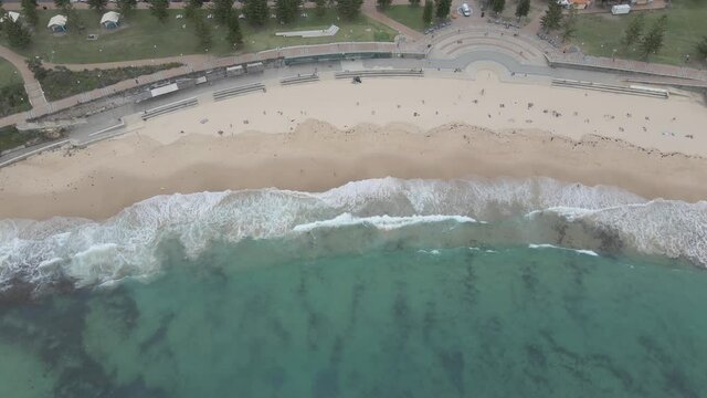 Tourist Sunbathers On Sandy Waterfront With Splashing Waves - Coogee Beach, Goldstein Reserve In Eastern Suburb Of Sydney, New South Wales, Australia. - Topdown Shot