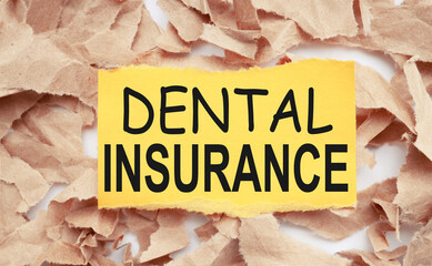 Dental insurance. text on white paper over torn paper background.