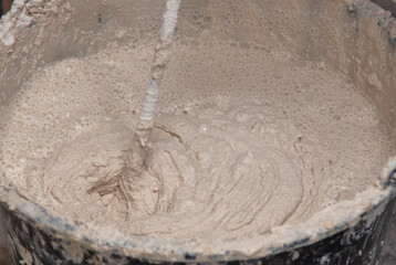 A worker kneads the mixture into plaster buckets. Home renovation