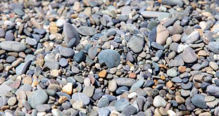 Stone pebbles on the seashore as a background. Close-up