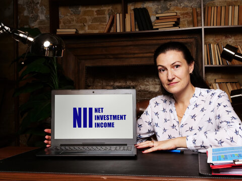Woman using laptop computer with  NII NET INVESTMENT INCOME icon on screen background, success in business concept