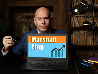 Financial concept meaning Marshall Plan with phrase on laptop in hand.