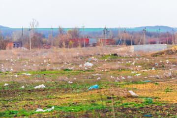 Plastic garbage thrown out in nature among grass. Sunny autumn day. The concept of ecology and...