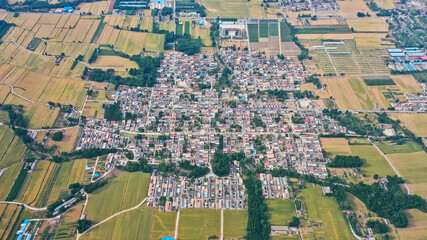 Aerial view of beautiful rural scenery in spring, clean-lined houses and fields on the plain