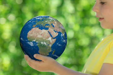 Child holding Earth planet in hands.Elements of this image furnished by NASA