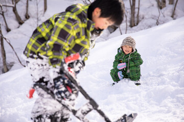 スキー場でスキーウェアーを着て兄弟で遊んでいる　winter