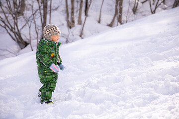 小さい男の子がスキー場にスキーウェアを着て立っている　kids