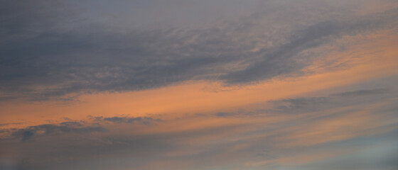 Bannière d'arrière-plan de texture de ciel au coucher du soleil, et légers nuages colorés orange et bleu foncé sur fond de ciel gris