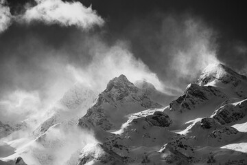 snow covered mountains with heavy wind