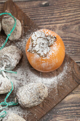 Delicious fresh and dried persimmon fruits on wooden board