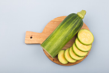 Courgette or Zucchini on wooden cutting board.