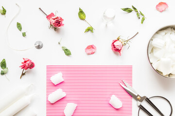 DIY concept. Wax, wick, dry roses - ingredients for making handmade candles on a light background. Flat lay. View from above.