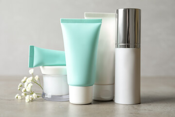 Set of luxury cosmetic products on light grey table