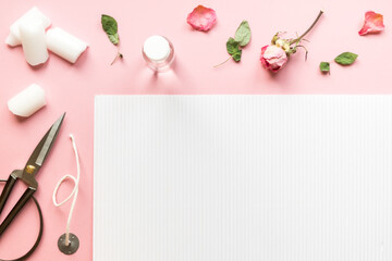 DIY concept. Wax, wick, dry roses - ingredients for making handmade candles on a pink background. Flat lay. View from above with copy space.