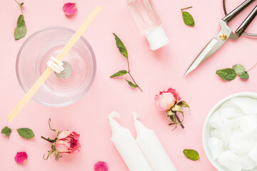 DIY concept. Wax, wick, dry roses - ingredients for making handmade candles on a pink background. Flat lay. View from above.