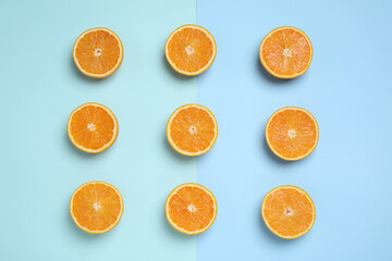 Cut oranges on color background, flat lay