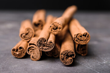 Aromatic cinnamon sticks on grey table, closeup