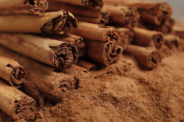 Cinnamon sticks and powder as background, closeup