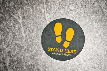 Stand here Text with thai language with the same meaning on the floor in department store